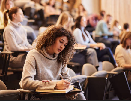 Student taking notes in lecture